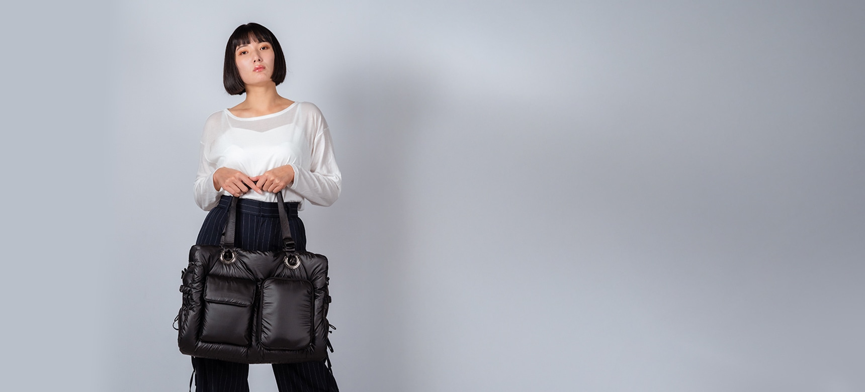 2色のバックを肩にかける女性