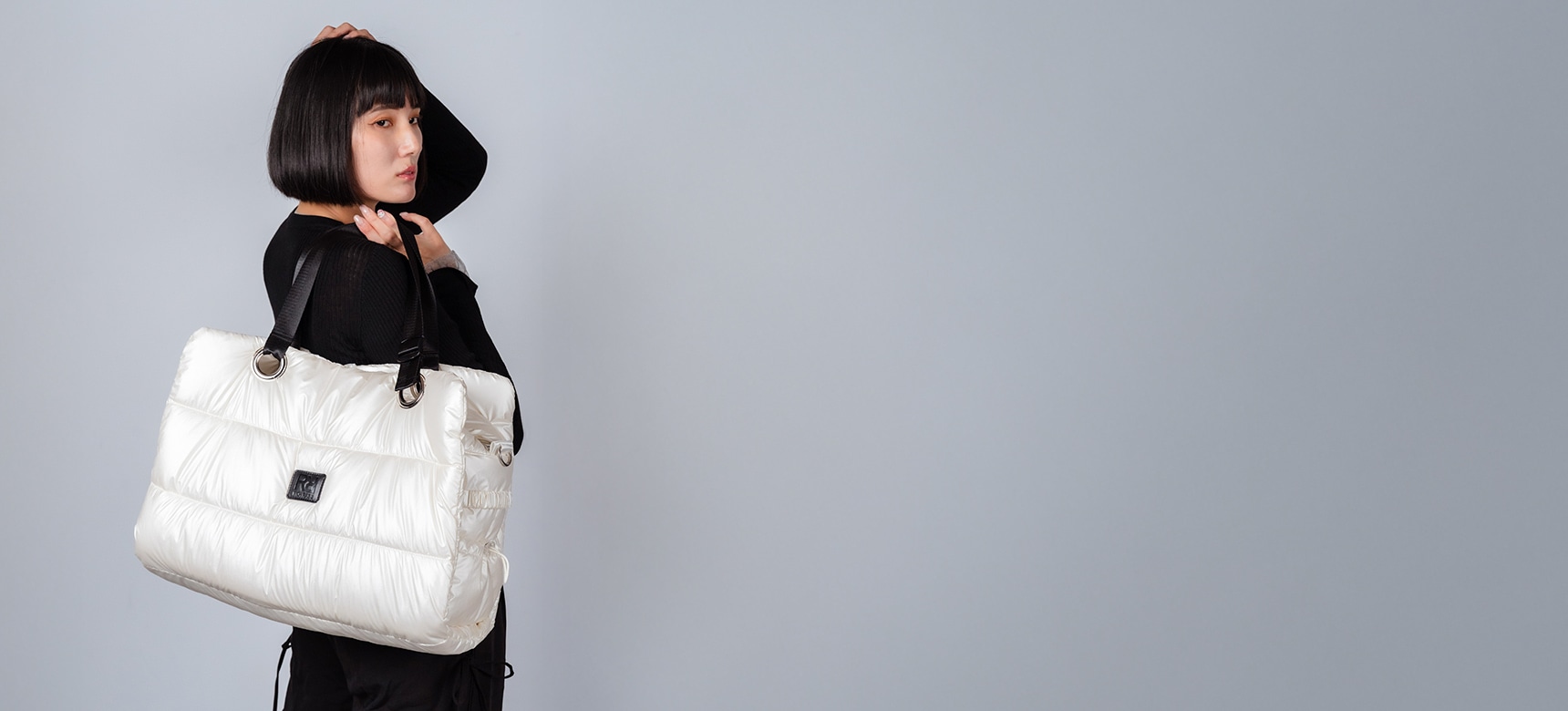 ホワイトのバックを肩にかける女性